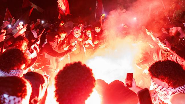 Pro-Palestine protesters release flares in Sydney on Monday. Picture: David Swift