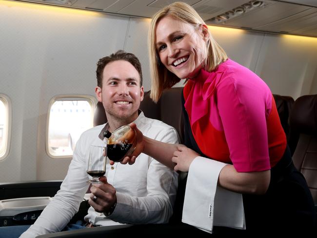 11/07/16 Qantas flight attendant Maria D'odorico serves Chad Elson from Seppeltsfield some of their 100 year old tawny port on a Boeing plane at Adelaide Airport. Seppeltsfield 100 year old port will soon be available on selected Qantas Boeing aircraft flights for business class passengers. photo Calum Robertson