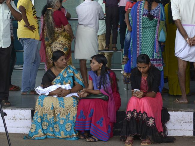 Passengers and relatives pictured waiting for news after first hearing that the Emirates flight EK521 travelling from Thiruvananthapuram to Dubai crash landed at Dubai International Airport. Picture: AFP/ STRINGER