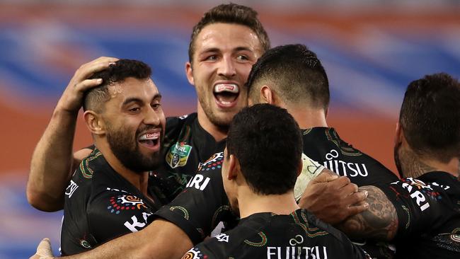 Alex Johnston of the Rabbitohs celebrates with his teammates after scoring a try.