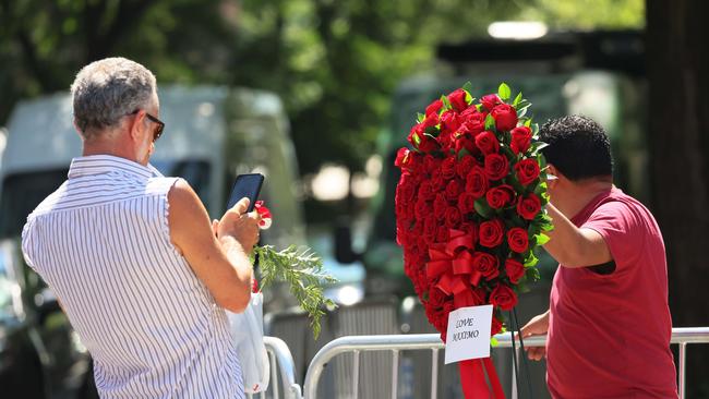 A man takes a photo of flower arrangements at the funeral of Ivana Trump. Picture: AFP