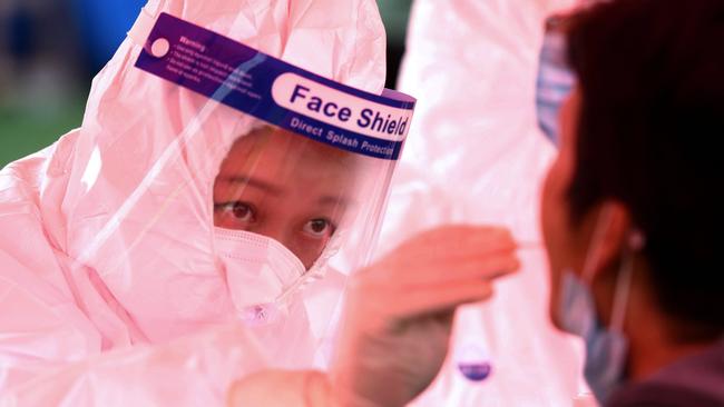 A health worker takes a swab from a resident in Qingdao. Picture: AFP