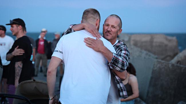 Many mourners embraced as they remembered James at Stockton breakwall. Picture: Adam Yip