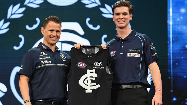 Carlton coach Brendon Bolton presents Paddy Dow with a Blues jumper.