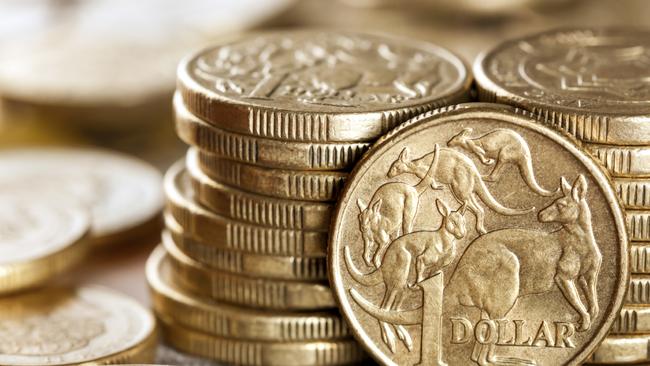 Stacks of Australian one dollar coins. Focus on front coin.