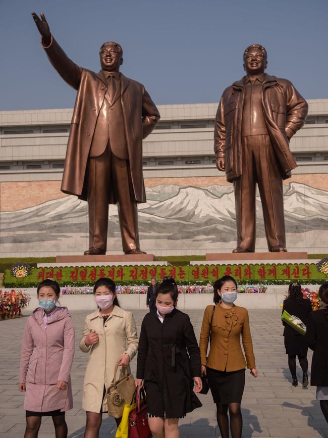 People wearing face masks leave after laying flowers before the statues of late North Korean leaders Kim Il-sung and Kim Jong-il on the occasion of the 108th birthday of late North Korean leader Kim Il-sung, known as the 'Day of the Sun. Picture: AFP
