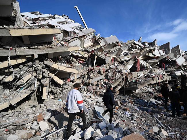 Relatives of victims stand beside the rubble of a collapsed building in the southeastern Turkish city of Kahramanmaras. Picture: AFP