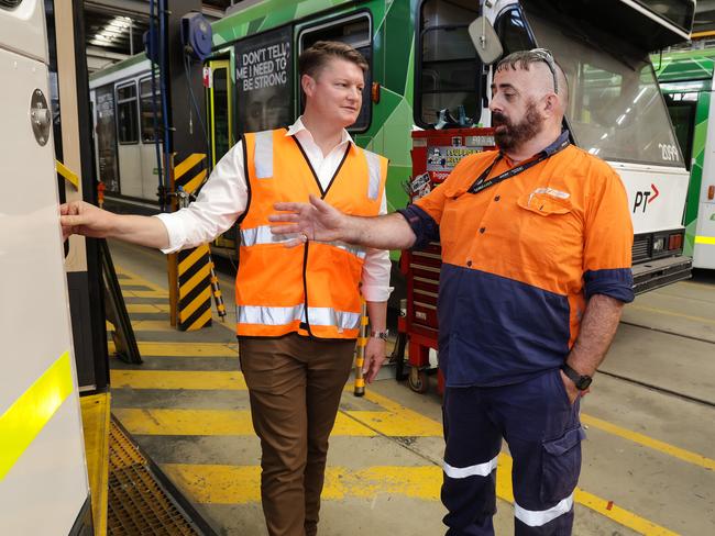 Tram vehicle body builder Pat Byrnes shows the Minister for Public Transport Ben Carroll a recently repaired tram. Picture: NCA NewsWire / Ian Currie