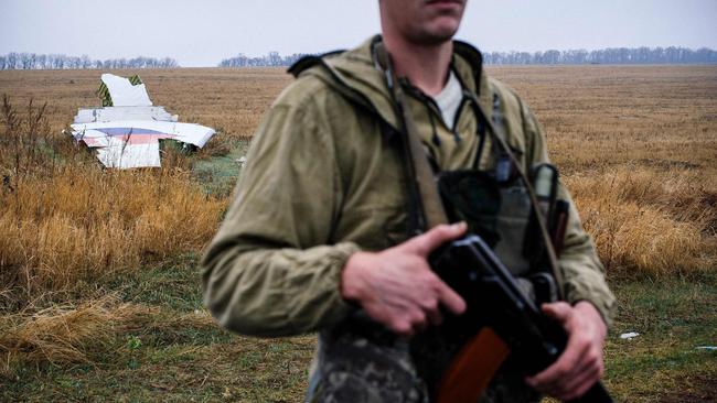 A pro-Russian gunman stands guard next to parts of the Malaysia Airlines Flight MH17 at the crash site near the village of Hrabove (Grabovo), some 80km east of Donetsk. Picture: AFP