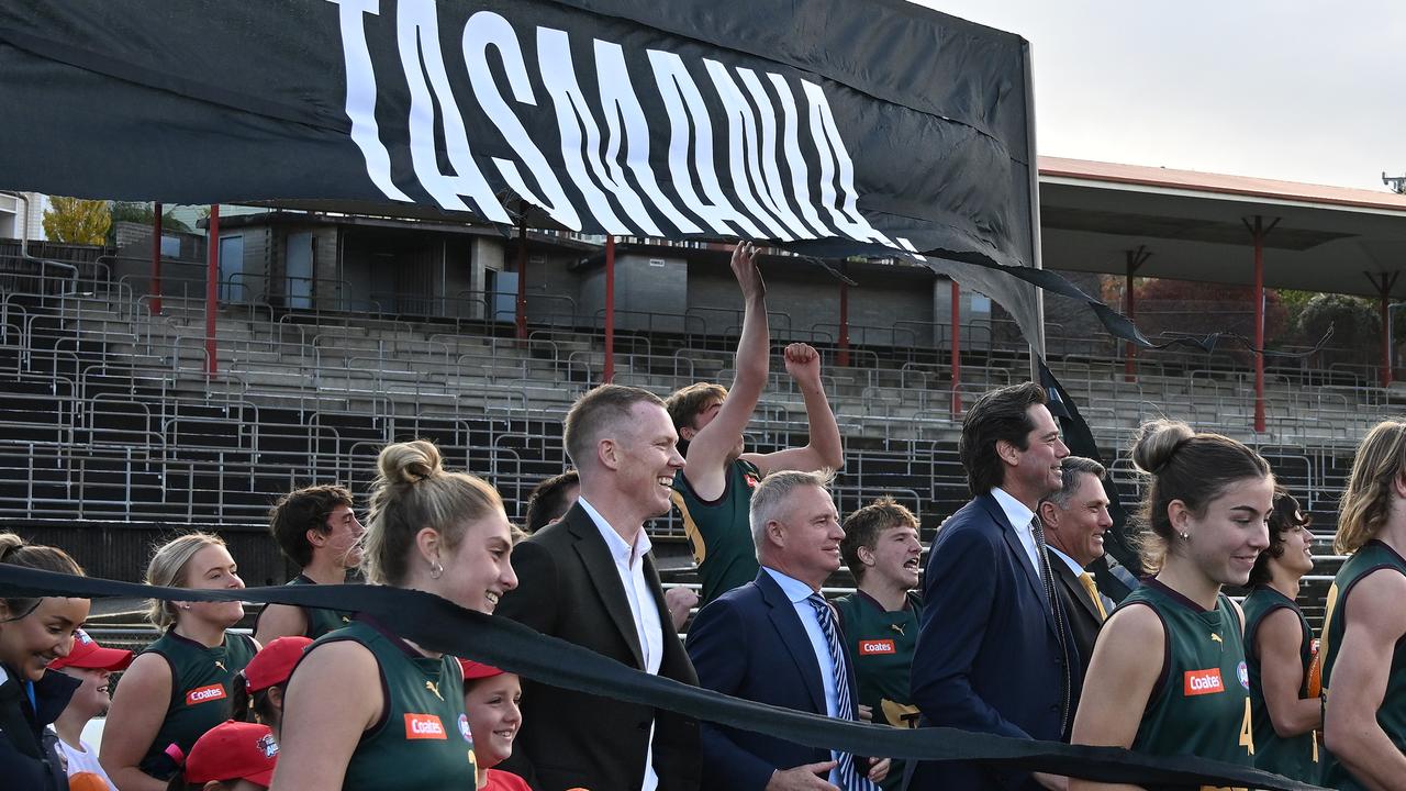 Gillon McLachlan, Tasmanian Premier Jeremy Rockliff, Deputy PM Richard Marles, and Jack Riewoldt are running through a banner as part of the announcement that there will be a 19th AFL team in Tasmania. Picture: Getty Images