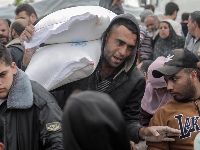 KHAN YUNIS, GAZA - NOVEMBER 22: UNRWA distributes flour to Palestinian refugees on November 22, 2023 in Khan Yunis, Gaza. On Tuesday night, Israel and Hamas agreed to a four-day pause in fighting that would entail the release of 50 hostages, as well as the release of 150 Palestinian prisoners. But the start of the short-term truce had not been confirmed as of Wednesday morning and air strikes continued in the territory overnight. (Photo by Ahmad Hasaballah/Getty Images) *** BESTPIX ***