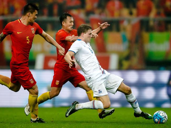 Bjorn Bergmann Sigurdarson (R) of Iceland fights for the ball with Fan Xiaodong and Yang Shanping (L) of China during 2017 Gree China Cup International Football Championship group match at Guangxi Sports Center Stadium in Nanning, south China's Guangxi province on January 10, 2017. / AFP PHOTO / STR / CHINA OUT