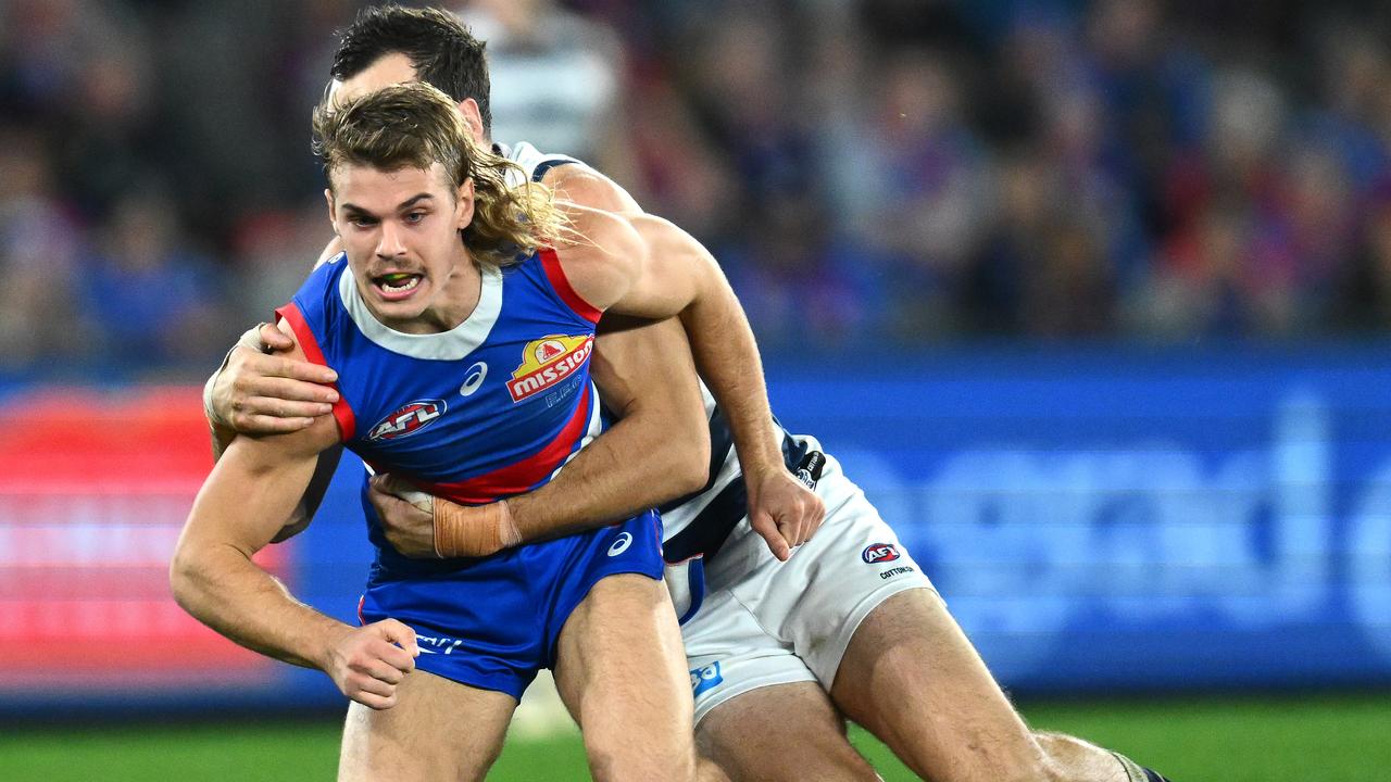 MELBOURNE, AUSTRALIA - JUNE 03: Bailey Smith of the Bulldogs handballs whilst being tackled by Jonathon Ceglar of the Cats during the round 12 AFL match between Western Bulldogs and Geelong Cats at Marvel Stadium, on June 03, 2023, in Melbourne, Australia. (Photo by Quinn Rooney/Getty Images)