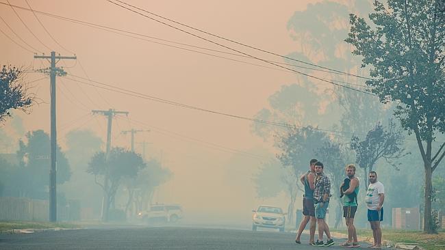 Locals can only watch on as fire threatens houses.