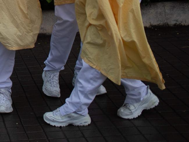 Heathcare workers wearing face masks and protective suits acknowledge applause outside the Hospital de Barcelona on April 13, 2020 in Barcelona, during a national lockdown to prevent the spread of the COVID-19 disease. - Spain reopened parts of its coronavirus-stricken economy on Monday as slowing death tolls in some of the worst-hit countries boosted hopes the outbreak may be peaking and lockdowns could soon be eased. (Photo by Josep LAGO / AFP)