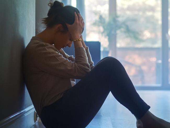 istock generic:  woman, abuse, DV, domestic violence, harassment, sexual harassment.   Sad Young Woman Sitting on the Floor In the Hallway of Her Appartment, Covering Face with Hands. Atmosphere of Depression, Trouble in Relationship, Death in the Family. Dramatic Bad News Moment . Picture: istock
