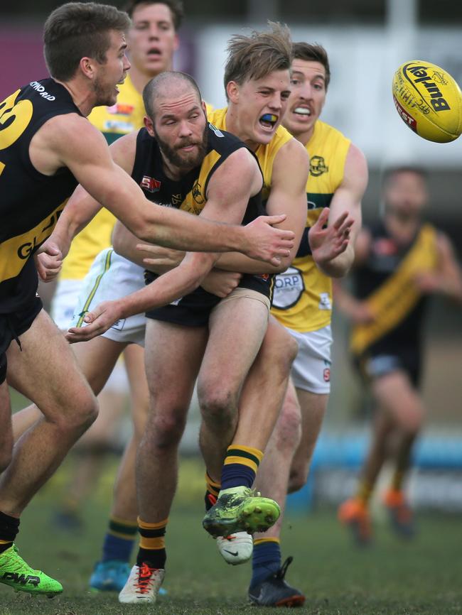 Glenelg's Aaron Joseph gets a handball out under pressure from Eagle Nick Hayes. Picture: AAP/Dean Martin