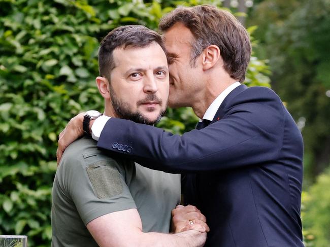 TOPSHOT - Ukrainian President Volodymyr Zelensky (L) and French Fresident Emmanuel Macron embrace after giving a press conference in Kyiv, on June 16, 2022. - The leaders of major EU powers France, Germany and Italy vowed on June 16 to help Ukraine defeat Russia and to rebuild its shattered cities, in a visit to a war-torn Kyiv suburb. (Photo by Ludovic MARIN / POOL / AFP)