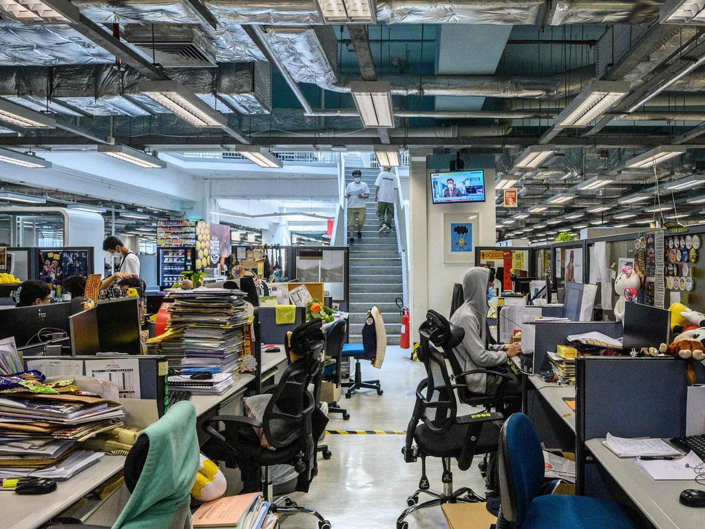 Employees work at their desks in the Apple Daily newsroom in Hong Kong after Hong Kong police arrested the chief editor and four executives of the pro-democracy newspaper.