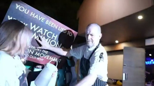 Mr Mountain pushes away signs during a confrontation with vegan activist Tash Peterson’s megaphone. Picture: 9 News