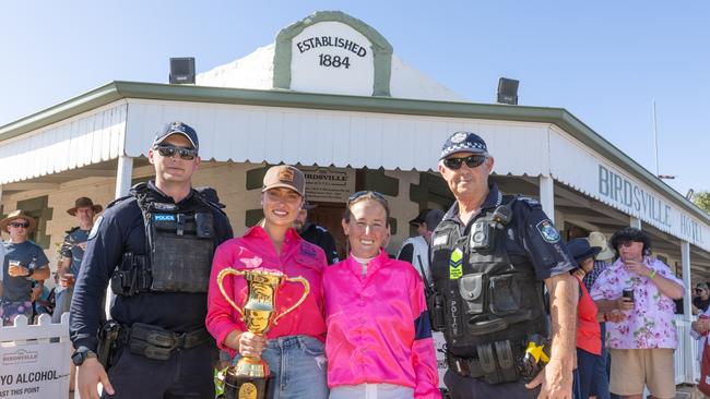 Acting senior constable in Birdsville Dan De Klerk, Birdsville Races ambassador Grace Hayden, a jockey and retiring senior constable Stephan Pursell at the 2024 Birdsville Races parade. Picture: Matt Williams