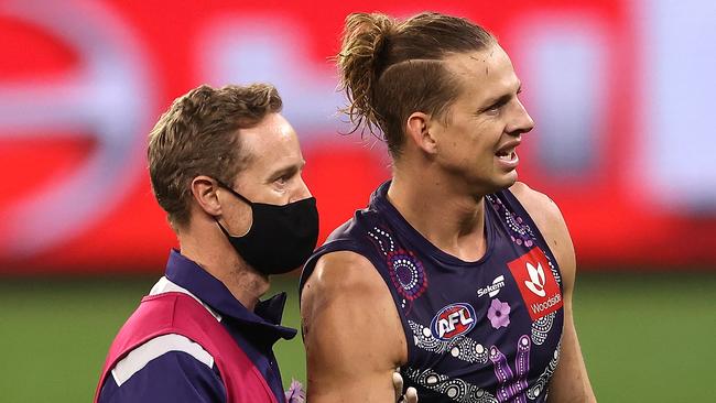 PERTH, AUSTRALIA - JUNE 06: Nat Fyfe of the Dockers is assisted  from the field by the club doctor with a shoulder injury during the round 12 AFL match between the Fremantle Dockers and the Western Bulldogs at Optus Stadium on June 06, 2021 in Perth, Australia. (Photo by Paul Kane/Getty Images)