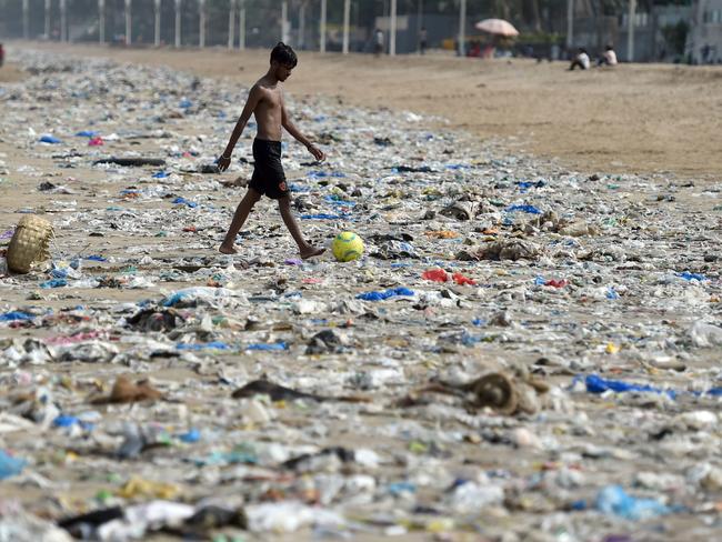 An Indian boy walks through plastic waste on Juhu beach in Mumbai on June 2, 2018. Picture: Punit Paranjpe