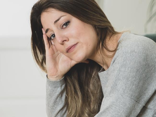 MENTAL HEALTH -  Depressed sad attractive woman crying on sofa couch at home feeling lonely tired and worried suffering depression in mental health, loneliness and isolation concept. Psychology, solitude and people Picture: Istock