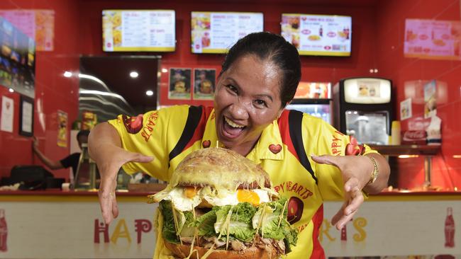 Happy Hearts owner and burger creator Fe Bacayo, stands next to the Super Supreme burger. The burger put all other burgers to shame with 1.5kg of meat, 1kg of cheese, 1kg bacon, eight eggs and more. Picture: Keri Megelus