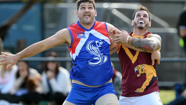 Brendan Fevola holds off opponent Shannon Schofield while playing for Sandown.