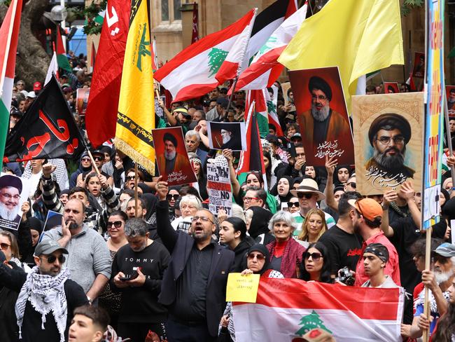 SYDNEY, AUSTRALIA - NewsWire Photos SEPTEMBER 29, 2024: People hold up pictures of Hezbollah leader Hassan Nasrallah and the Hezbollah flag at a protest at Town Hall in SydneyPicture: NewsWire / Damian Shaw