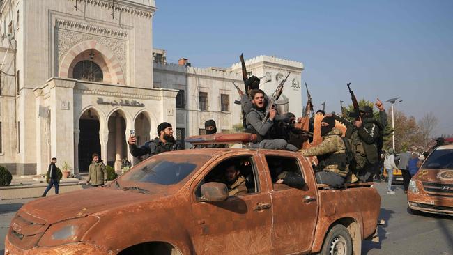 Syrian anti government fighters celebrate as they pour into the captured central-west city of Hama. Picture: AFP