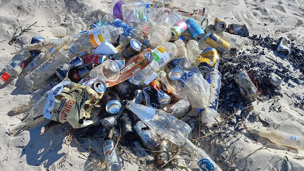 The remnants of a Rainbow Beach party, with broken glass and embers, that pose a threat to wildlife and humans.