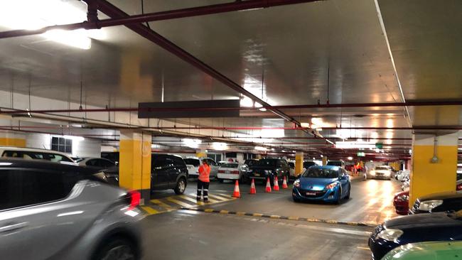 Traffic controllers manage the flow of vehicles as repair work continues across more than half of Westpoint Blacktown’s carpark.