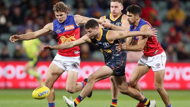 Luke Brown in front of Lions Deven Robertson and Charlie Cameron in Round 16. Picture: Sarah Reed/AFL Photos