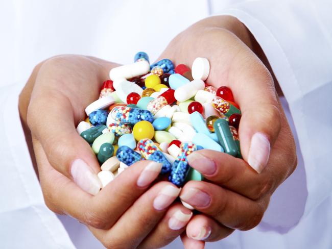 Close-up of vitamins and pills in human hands.