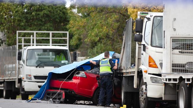 Police pull tarp over the Holden Commodore. Picture: Sarah Matray