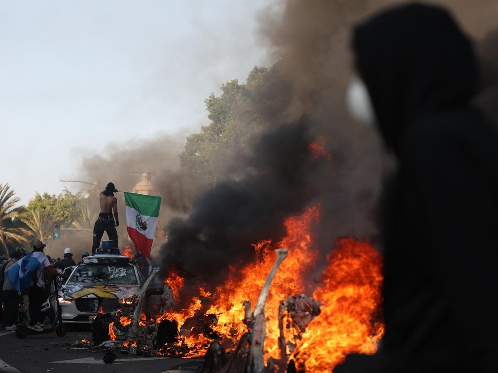 Burning cars line a street as people protest in Los Angeles, California. Picture: Getty Images via AFP