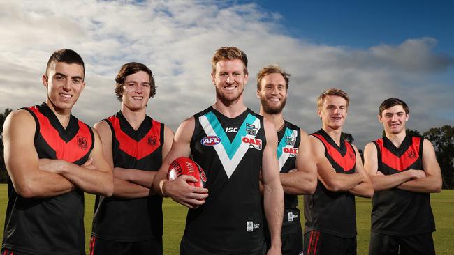 Rostrevor College footballers Luke Valente, Ben Jarvis, Jacob Kennerley and Cameron Taheny with Port Adelaide defenders Tom Jonas and Jack Hombsch at the school’s oval. Picture: Dylan Coker.