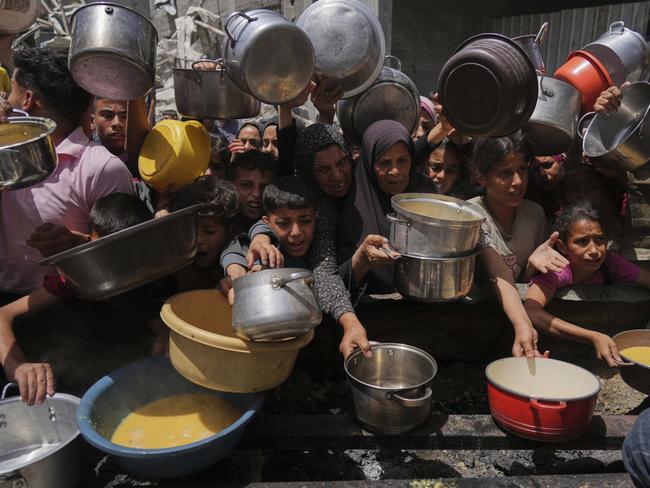 Palestinians struggle to get donated food at a community kitchen in Jabalia, northern Gaza Strip, Monday, May 19, 2025. (AP Photo/Jehad Alshrafi)