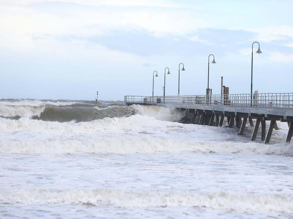 Wind whips up high waves near the Glenelg jetty. Picture: Dylan Coker