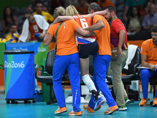 Netherlands’ Maret Balkestein-Grothues (C) is carried off of the court injured during the women’s qualifying volleyball match between the USA and the Netherlands