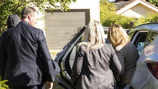 Friends and family are led into the house by detectives on Saturday. Picture: Jenny Evans