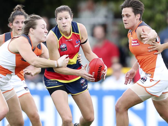 Crows ruck Jess Foley tries to get a handpass away during her side’s 2019 win over GWS. Pictured right is Courtney Gum, who is now her teammate. Picture: Sarah Reed