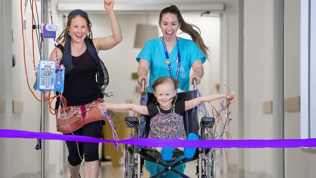 Sierra, 5, wins her own race through the Royal Children’s Hospital, with mum Trish and nurse Alyce Supek lending a helping hand. Picture: Jason Edwards