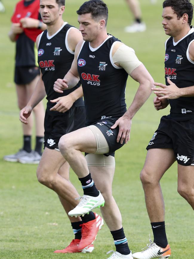 Tom Rockliff, with his reconstructed left shoulder strapped, training at Alberton, alongside Ryan Burton (left) and Steven Motlop. Picture: SARAH REED.