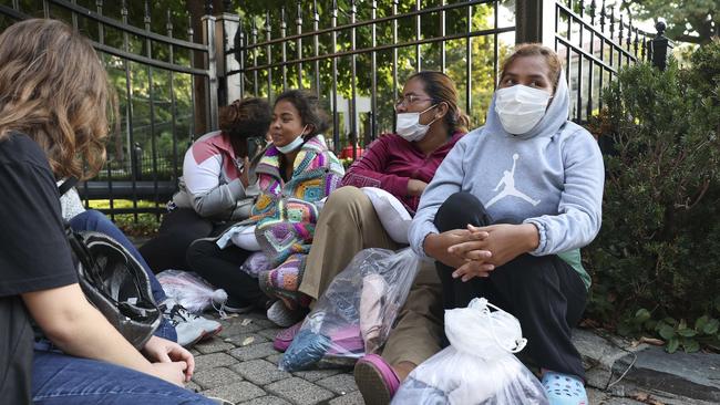 Migrants from Central and South America wait near the residence of US Vice President Kamala Harris after being dropped off on buses. Picture: AFP