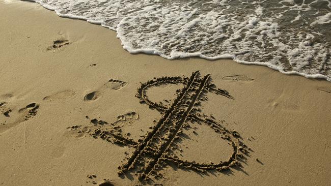 dollar sign drawn on sandy beach.