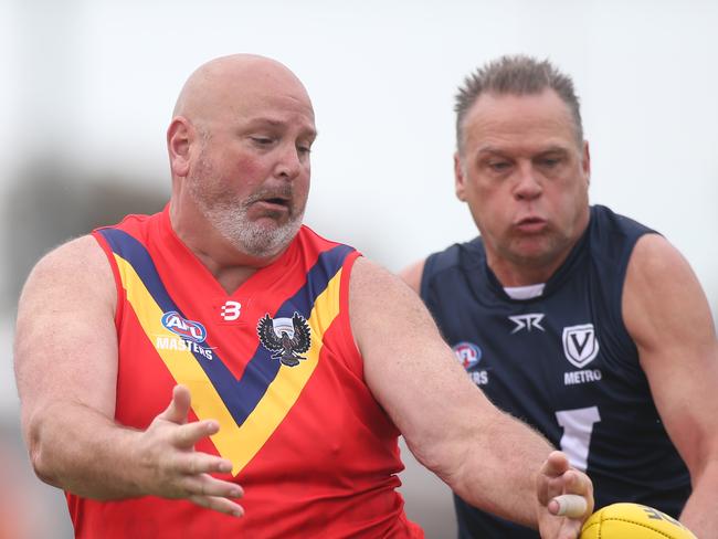 AFL Masters National Carnival day one at Barratt Reserve West Beach. SA versus Victoria Metro over 50Ãs Div 1. SAÃs Brad Rainsford in front of Victorian opponent. 25 September 2022. Picture Dean Martin