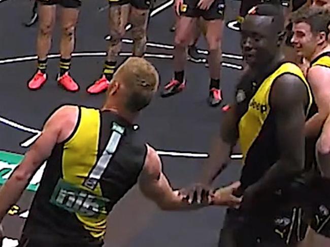 Richmond player Nick Vlastuin (1) is seen groping Mabior Chol (41) during team song in the rooms.,